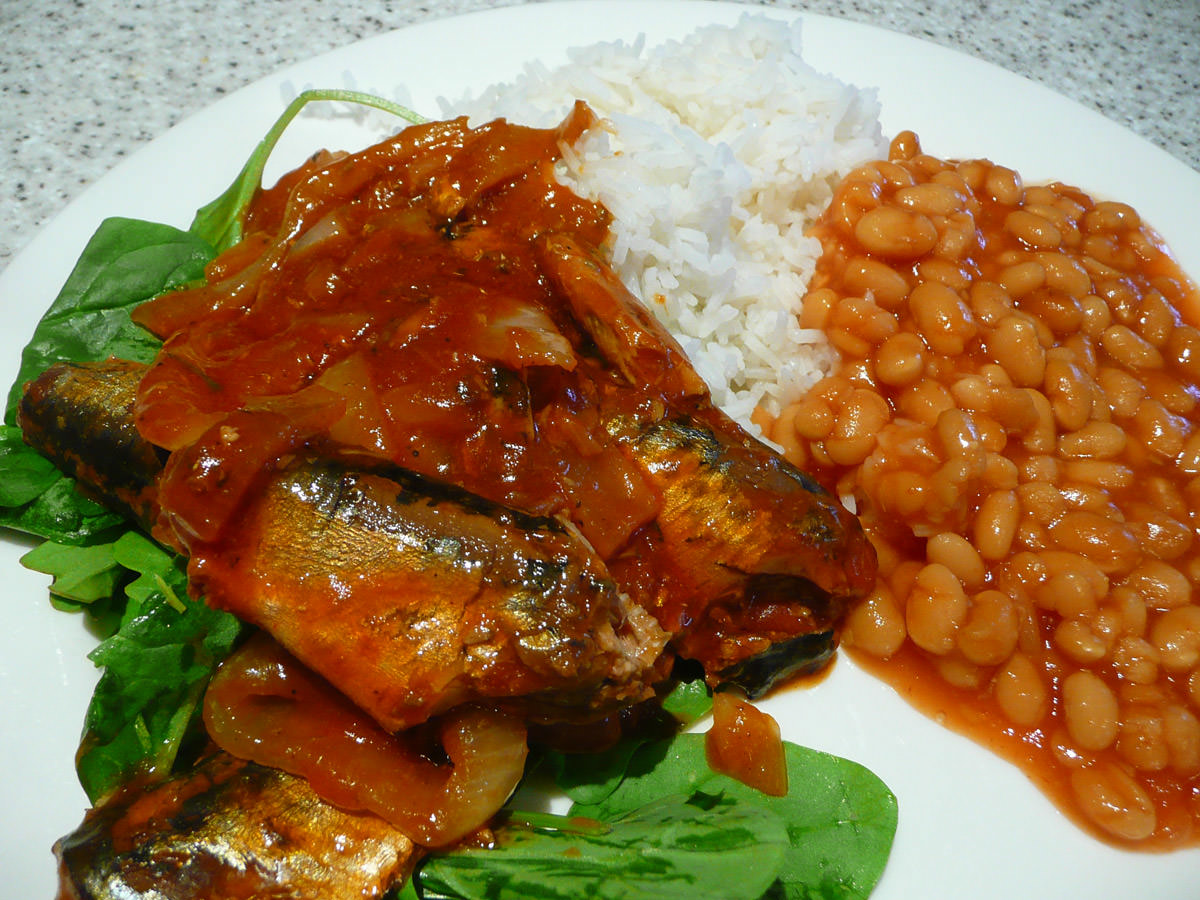 Sardines and onions in tomato sauce with rice, baked beans and salad