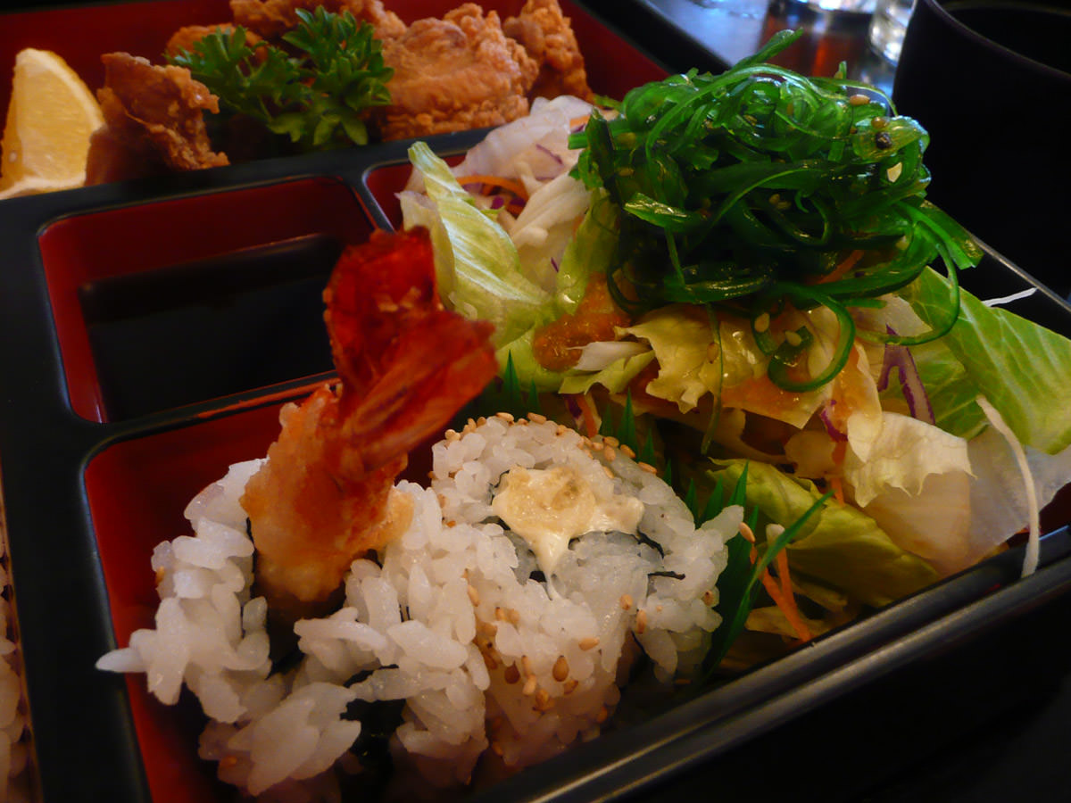 Teriyaki prawn sushi and salad topped with seaweed