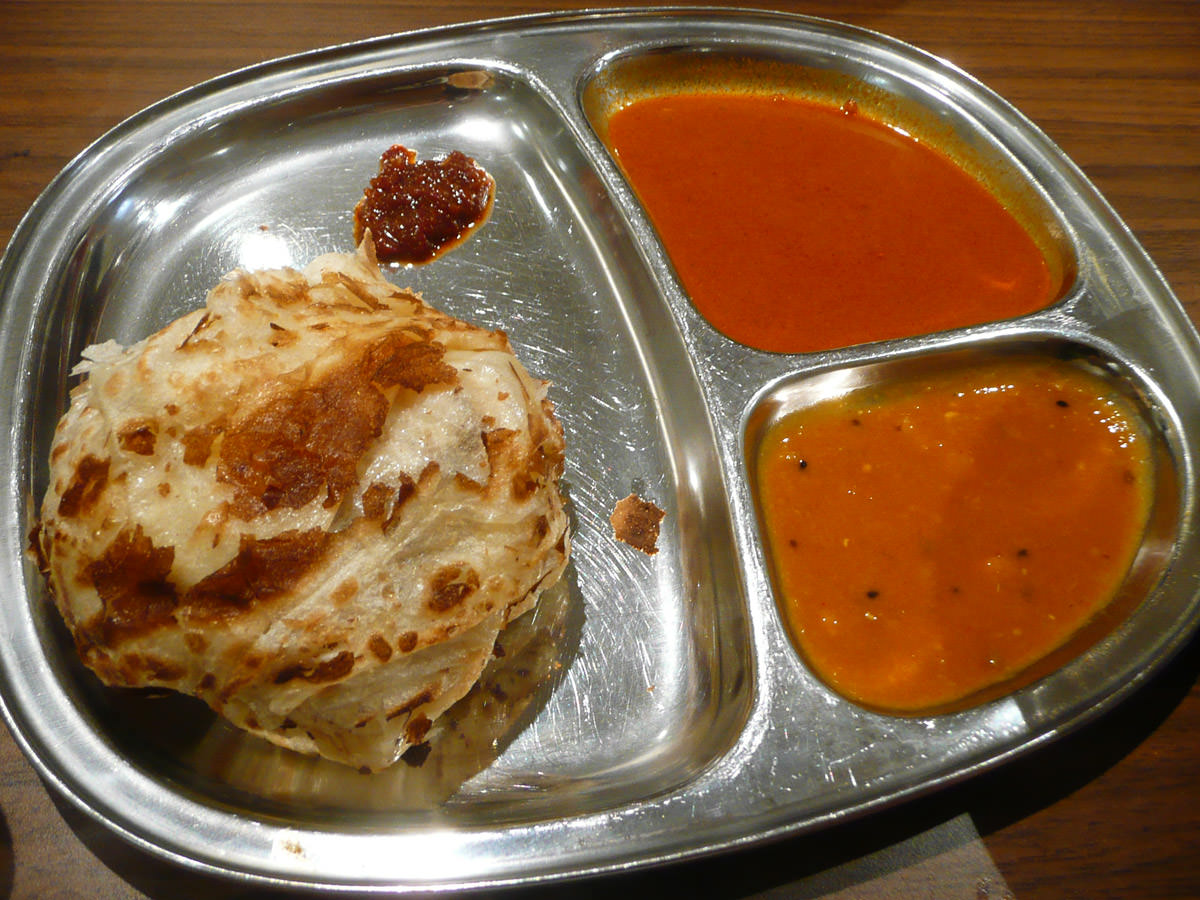 Roti canai with two curry gravies for dipping, and a little blob of sambal
