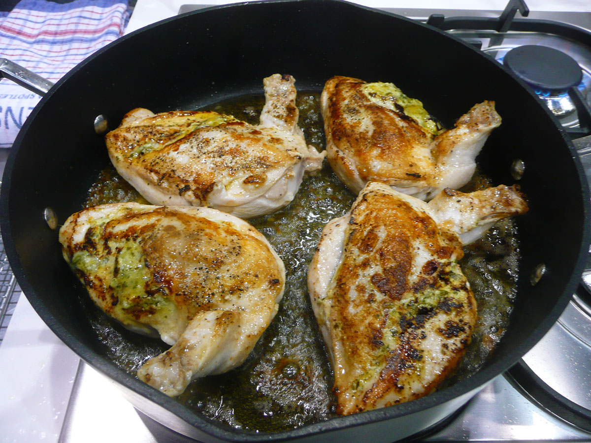 Grilled chicken breast with basil and parmesan sauce - sizzling in the pan
