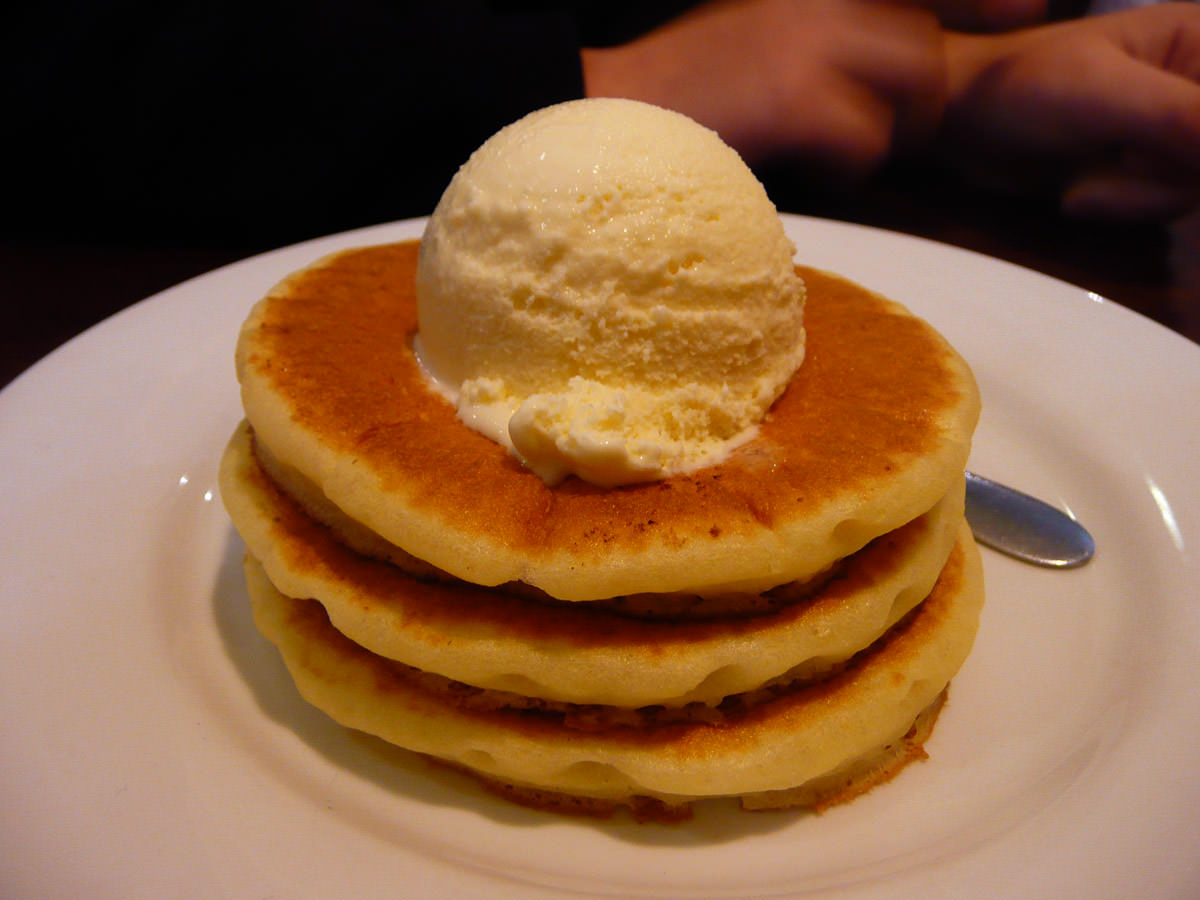 Mini pancake stack topped with a scoop of vanilla ice cream