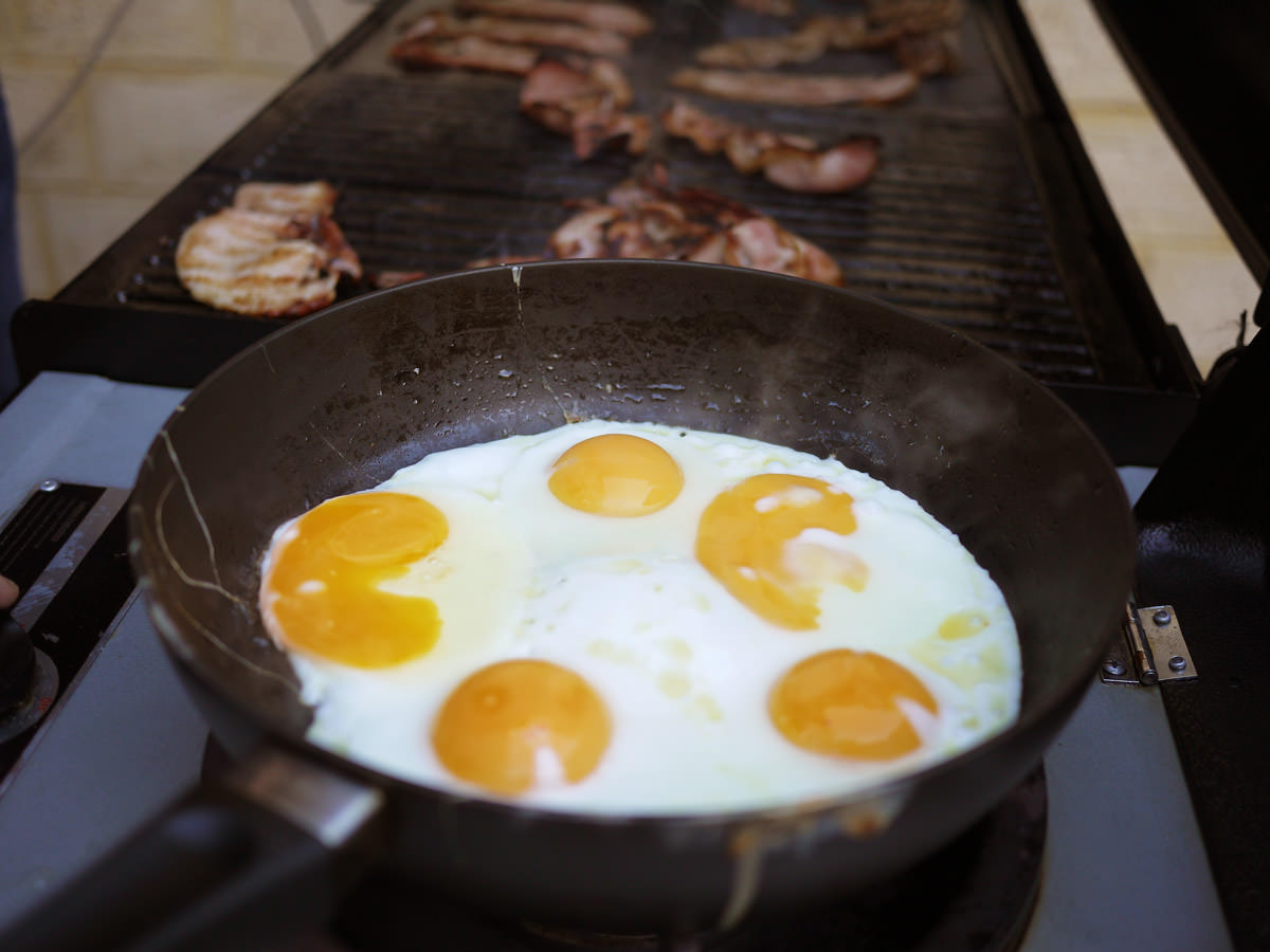 Frying eggs and bacon on the barbecue