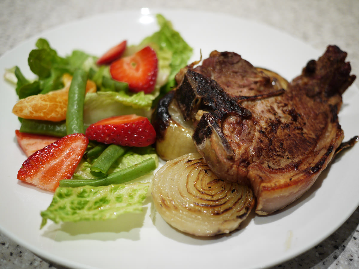 Grilled pork chop and onions with salad