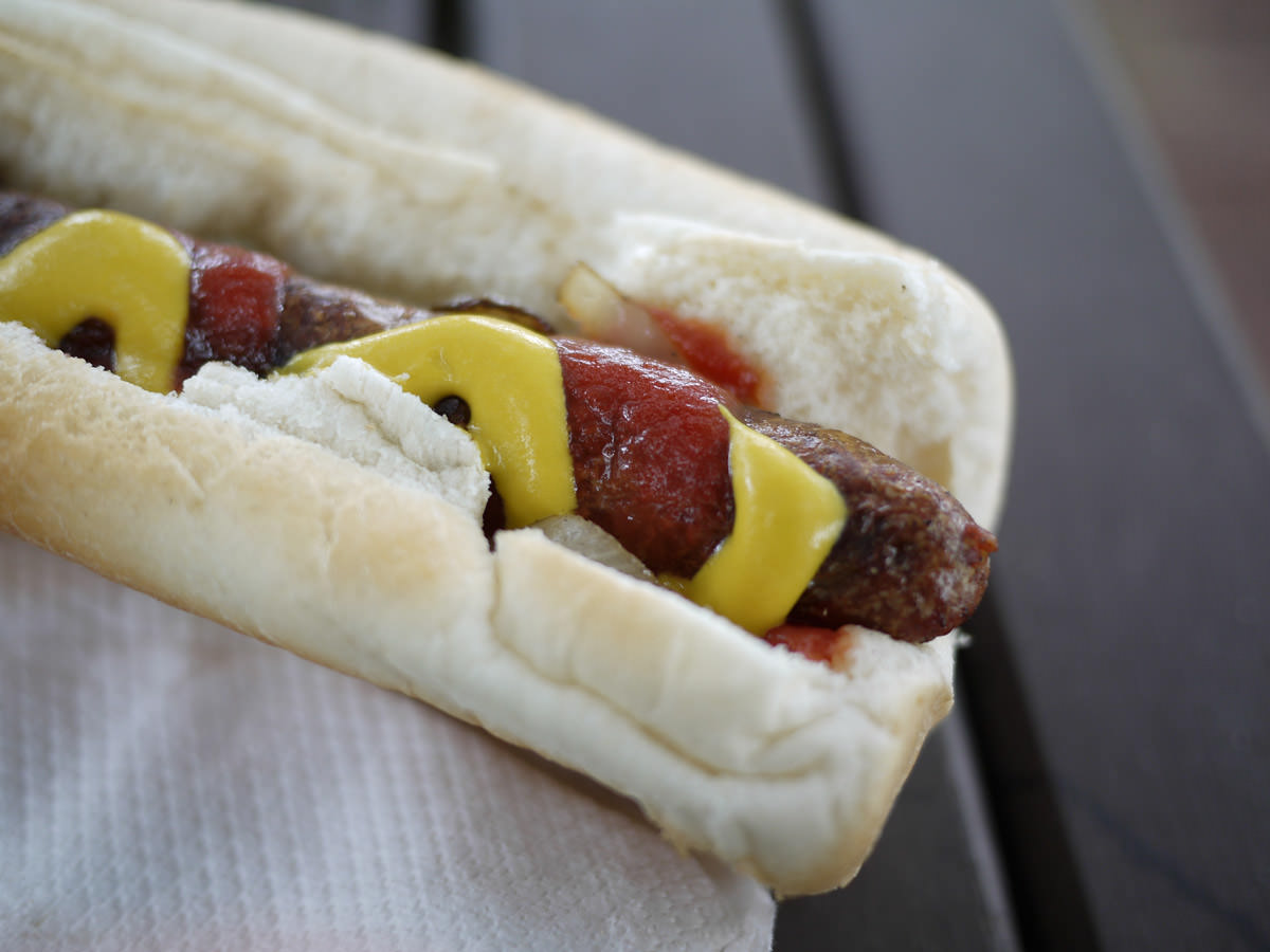 Sausage sizzle - hot dog with onions, tomatoes and mustard