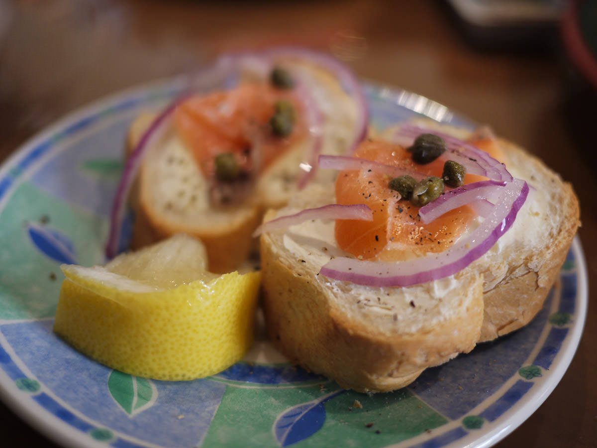 Smoked salmon, cream cheese, red onion and capers on bread with a squeeze of fresh lemon juice