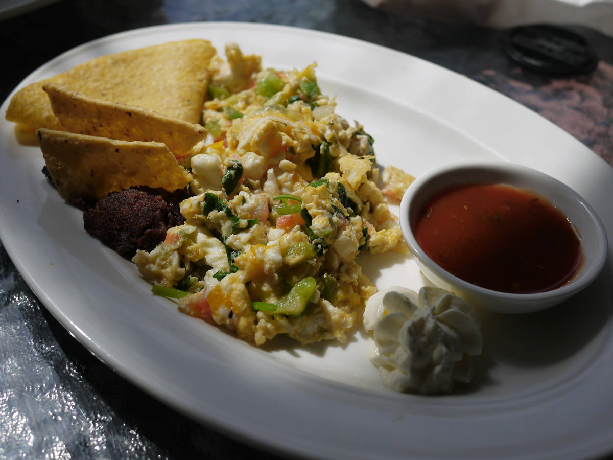 Spicy scrambled eggs served with refried beans and corn tortilla