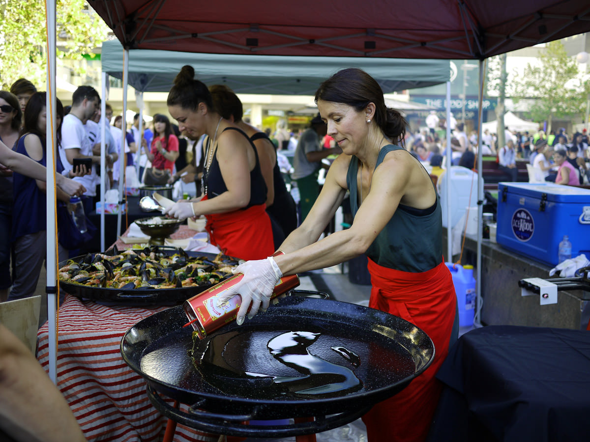 Serving up the first batch of paella, preparing the second batch