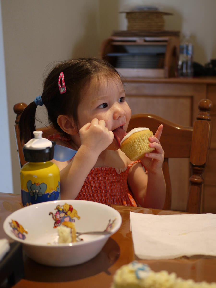 Zoe licks the lemon icing on cupcake
