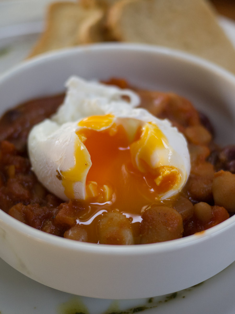 A perfectly gooey poached egg on baked beans