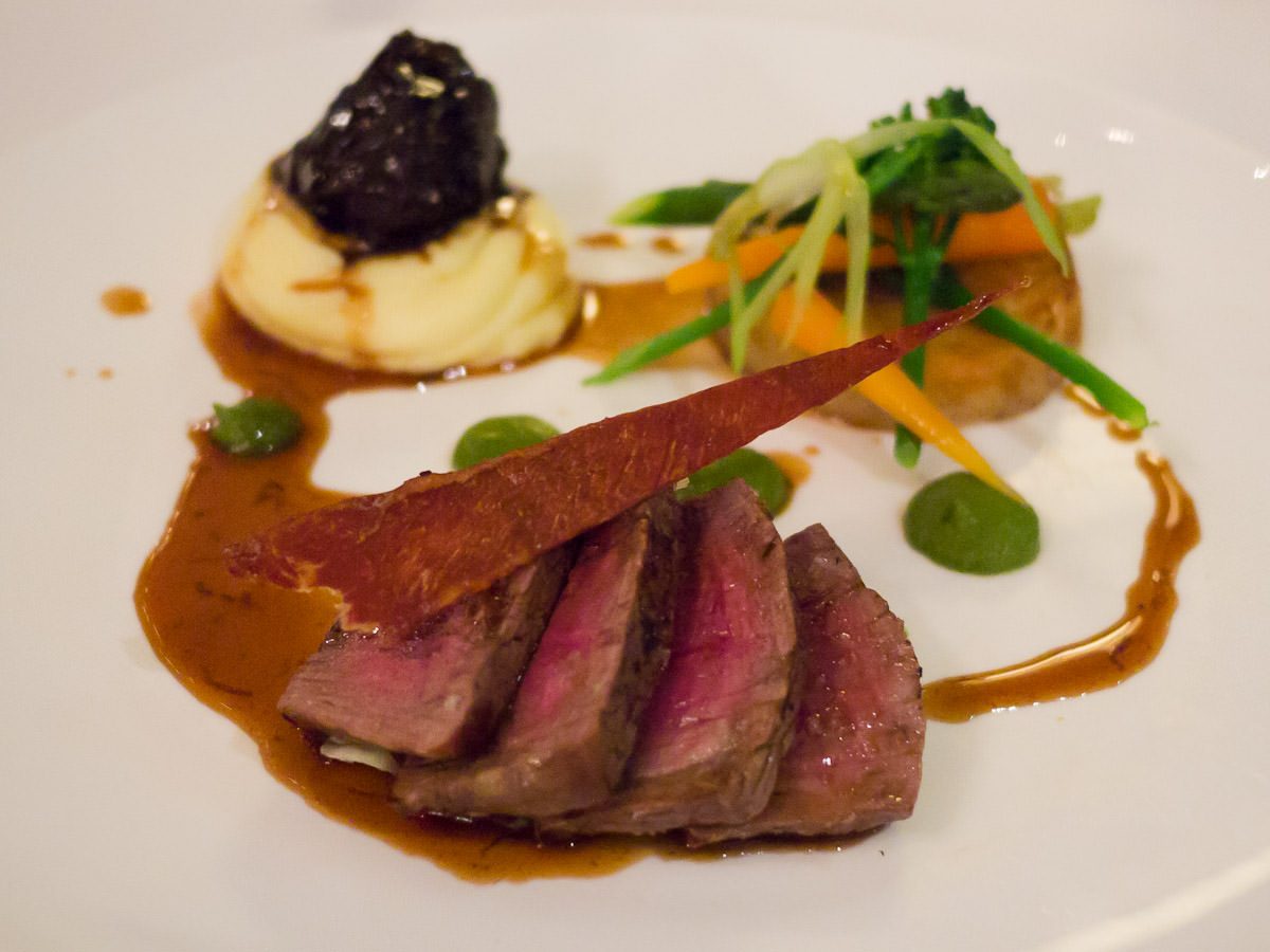 Beef fillet, braised cheek, fondant potato, young vegetables, madeira and truffle sauce. 