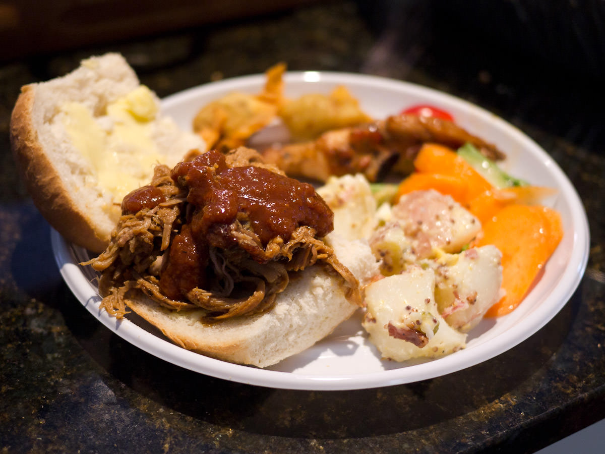 Pulled pork sandwich with homemade barbecue sauce and salads