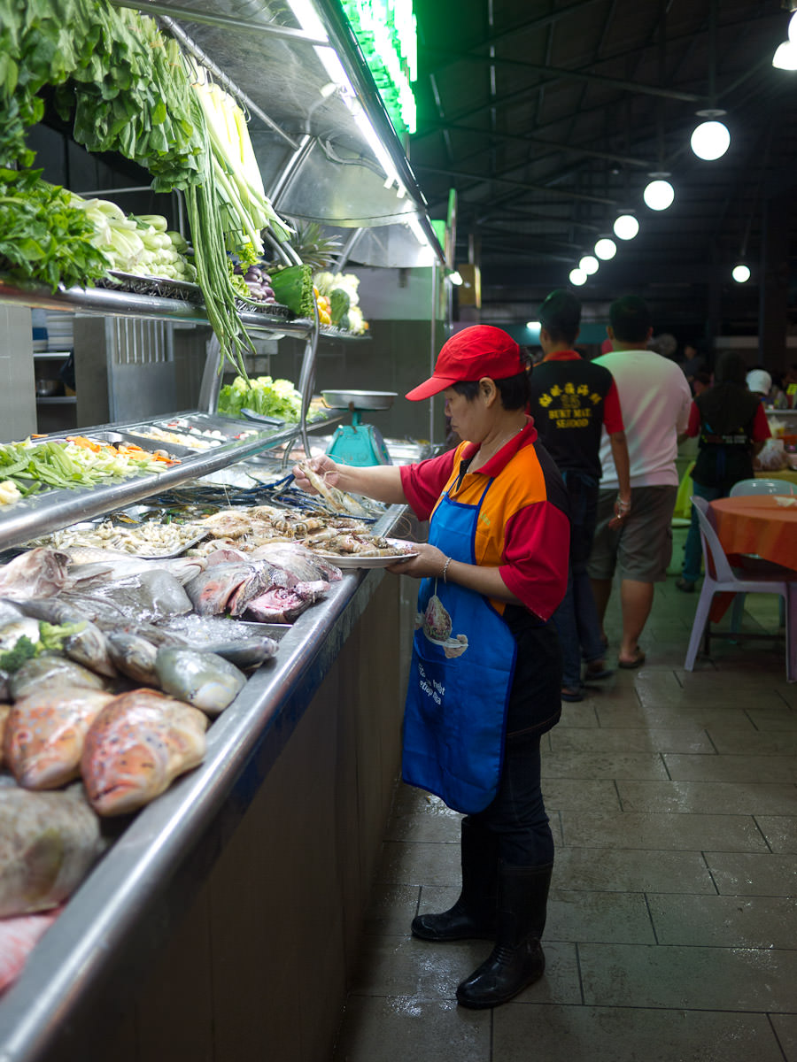 A staff member selects prawns to give to the kitchen to cook for a customer