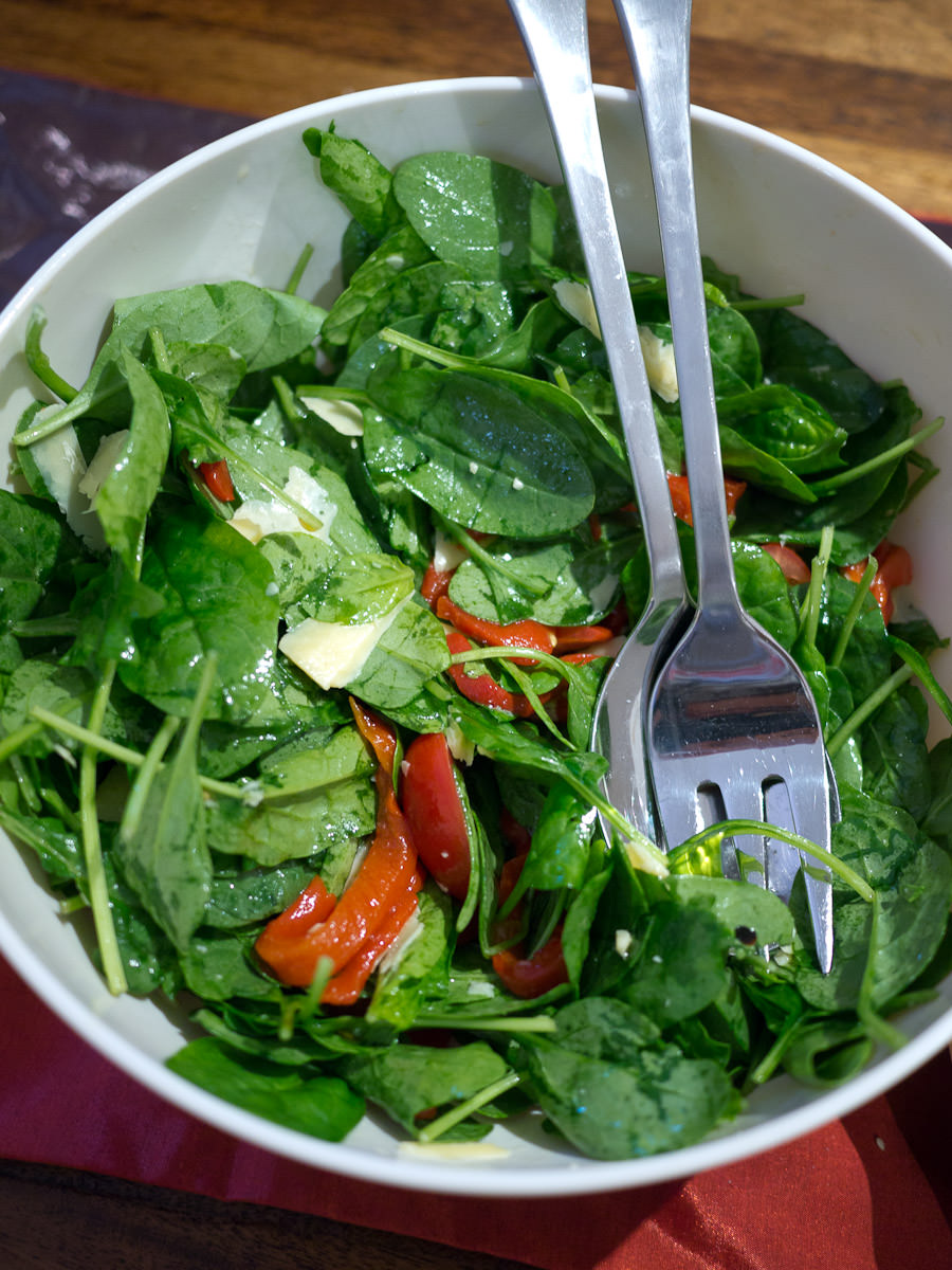 Spinach salad with mini roma tomatoes, roasted capsicum and parmesan