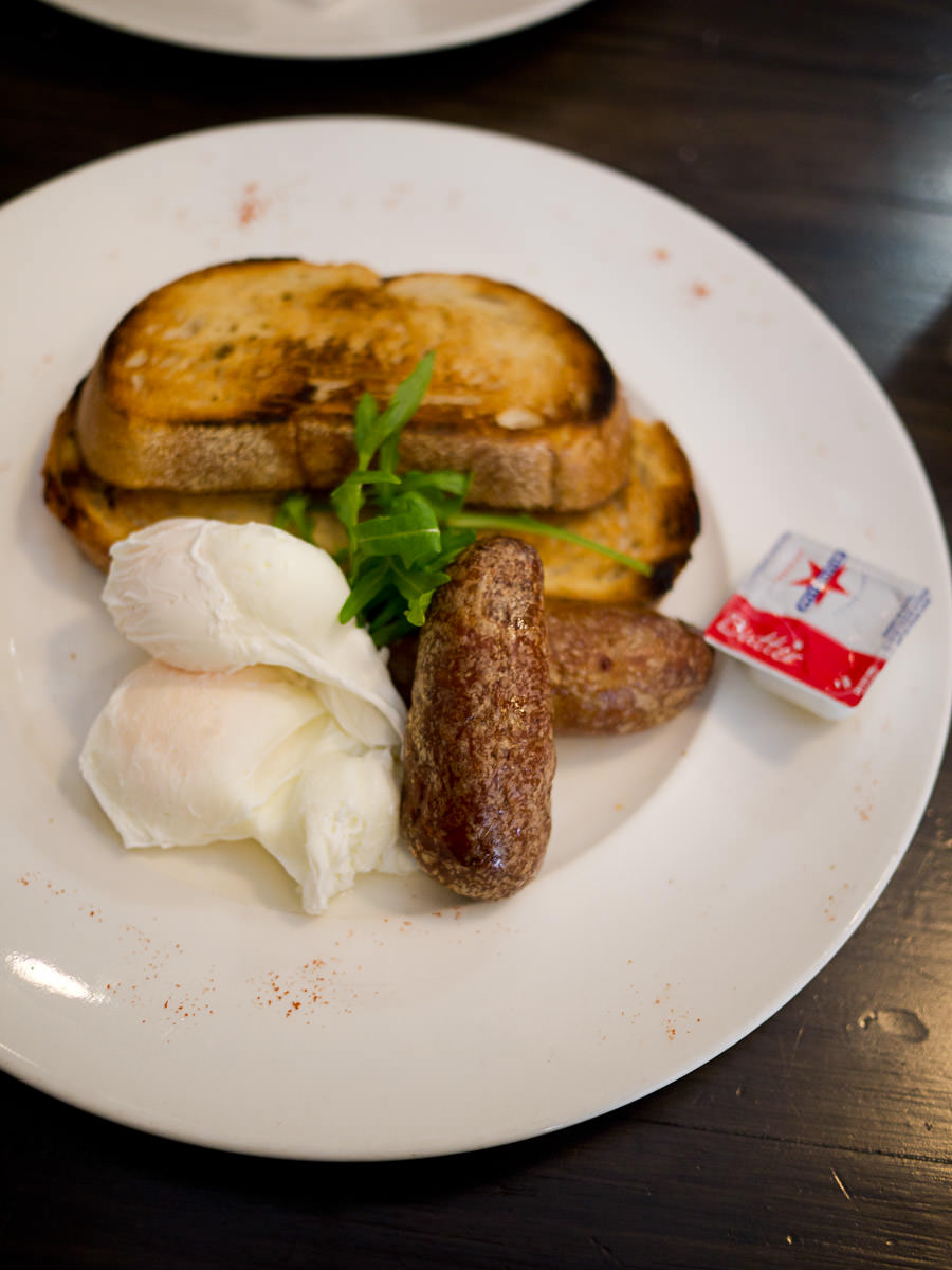 Poached free range eggs on toasted sour dough (AU$8) with pork sausage (AU$4)