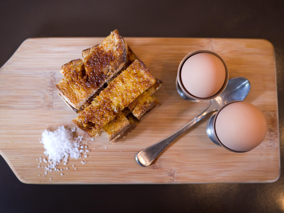 Two soft-boiled eggs with toasted Vegemite sourdough soldiers
