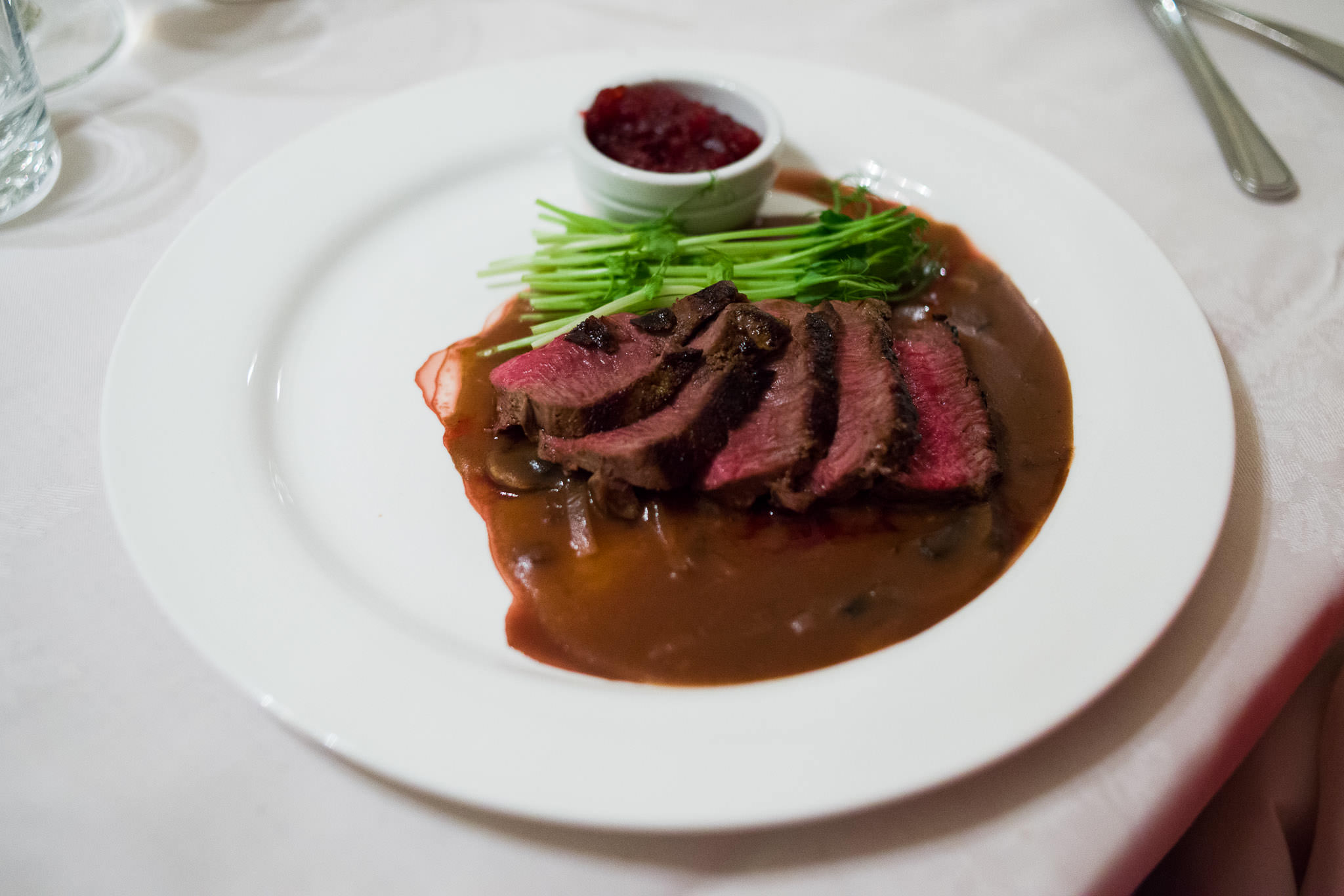 Grilled venison sirloin served on mushroom sauce with cranberry sauce on the side, Conti's, Woodvale