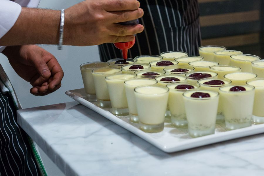 Topping pistachio panna cotta with berry sauce