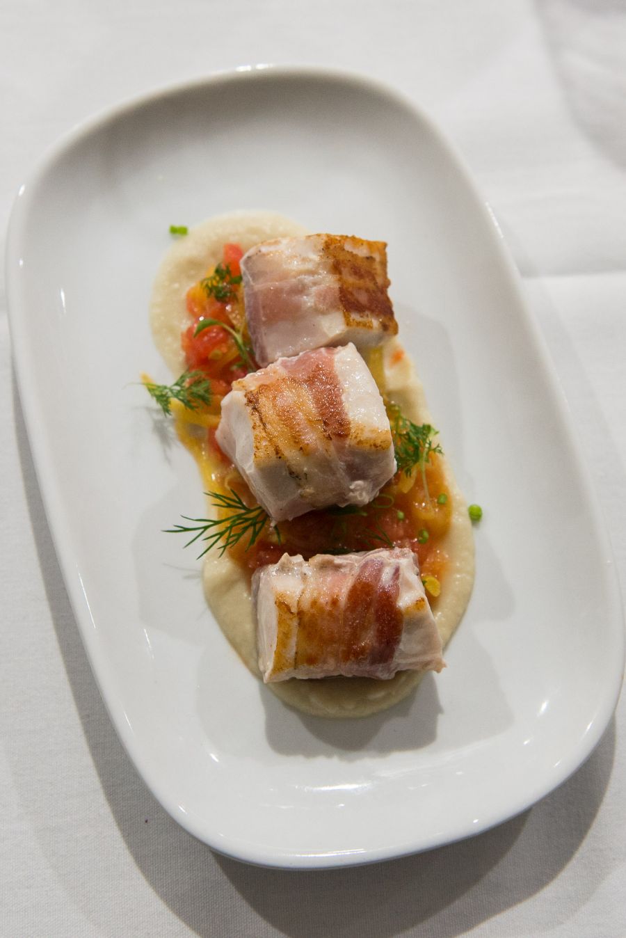 Third course: pancetta wrapped kingfish, warmed tomato and saffron, young fennel and soft herbs