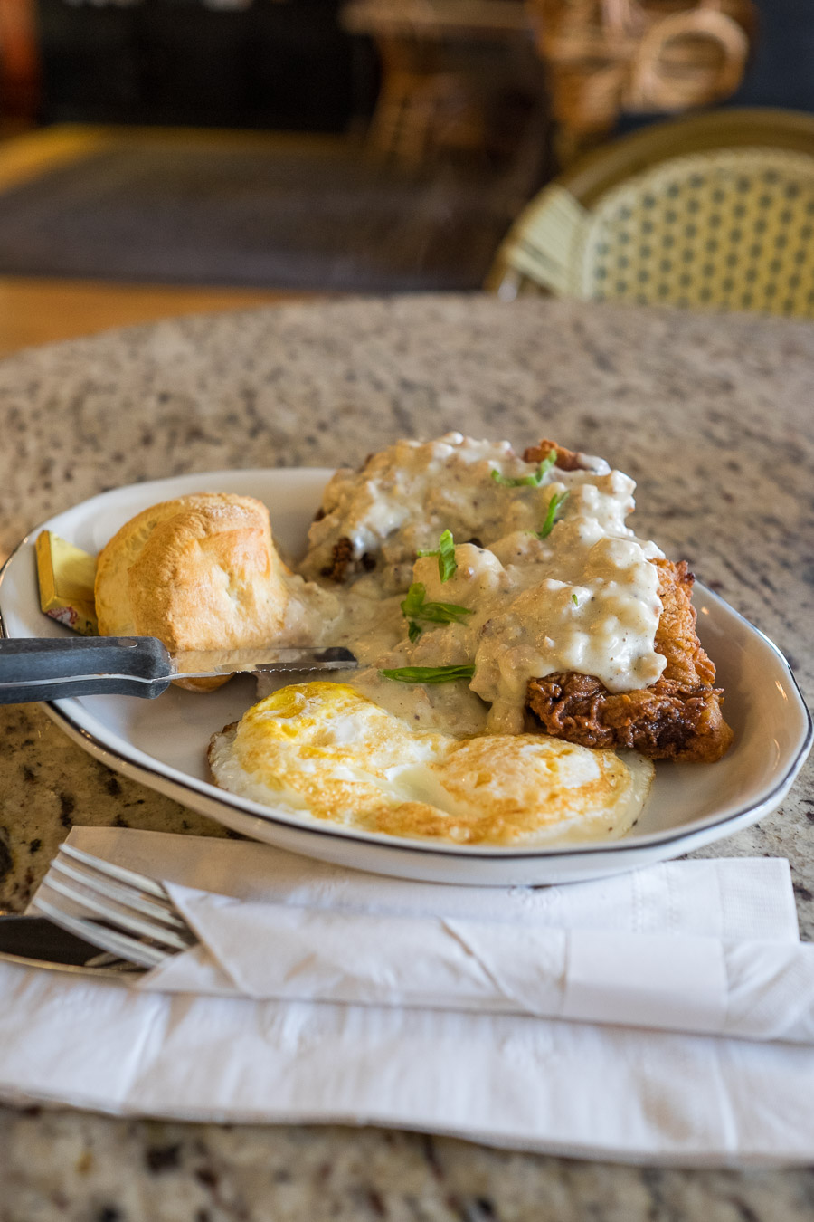 Chicken fried steak with country gravy, two eggs over easy and biscuits