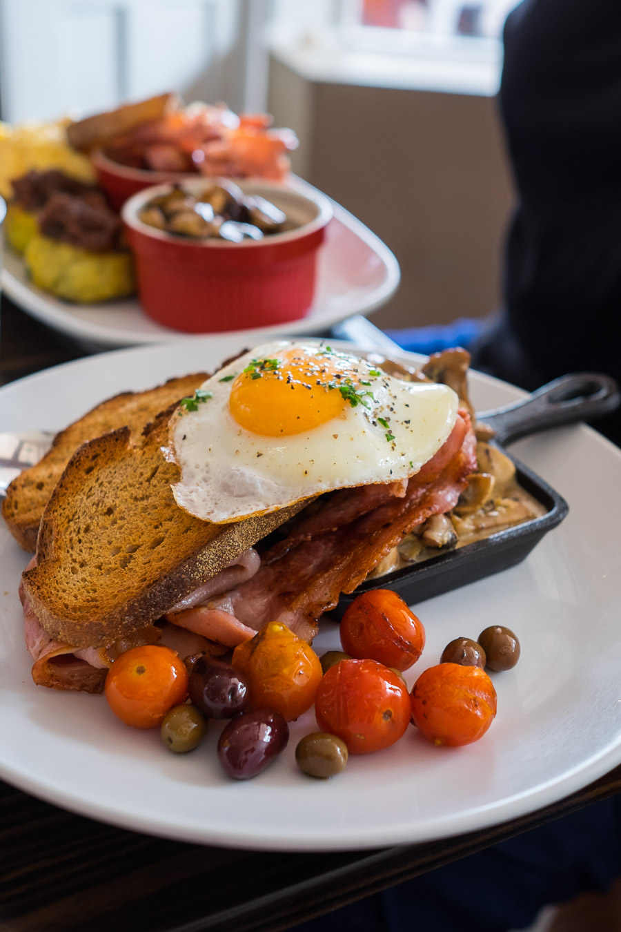 Creamed mushrooms with sunny side egg, bacon, roasted cherry tomatoes, olives and rye toast (AU$18.50)