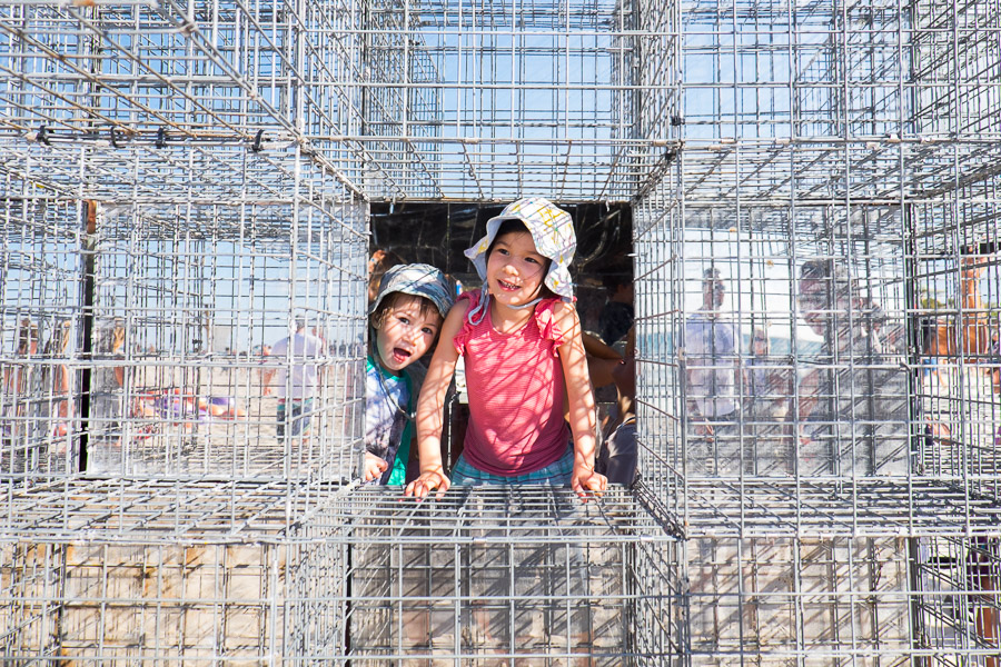 Zoe and Caleb in the House of mirrors by NEON - mirror finish stainless steel, gabion cages